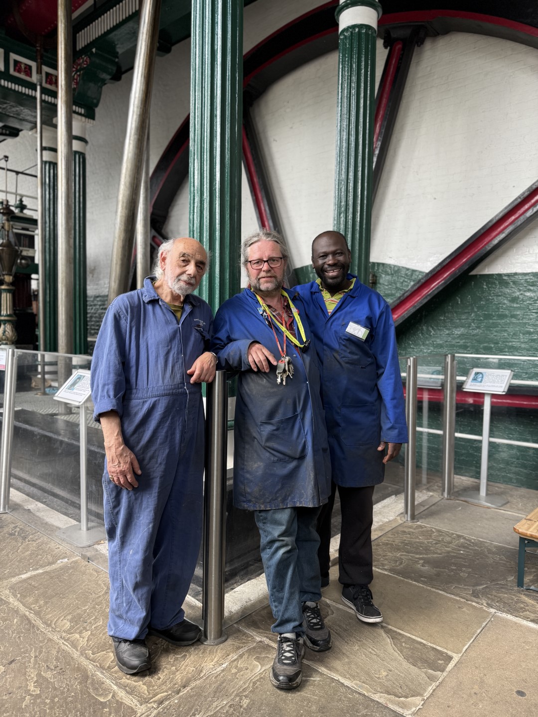 Three stewards of the Markfield Beam Engine and Museum in blue work coats