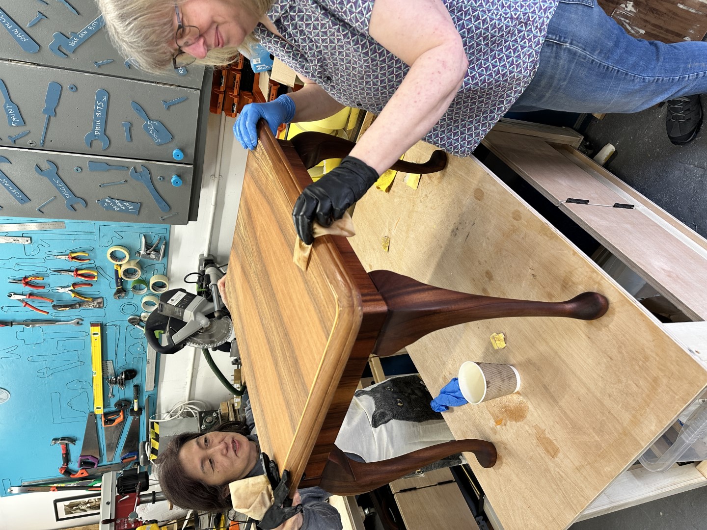 Volunteers restoring a table at The Tool House workshop